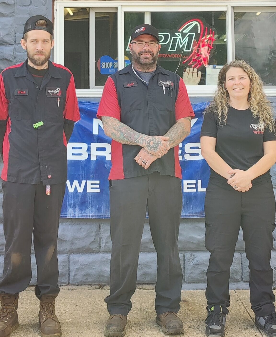 Photo of the RPM AutoWorx team standing under the sign of their auto repair shop on Grandview Avenue in McKeesport, PA.